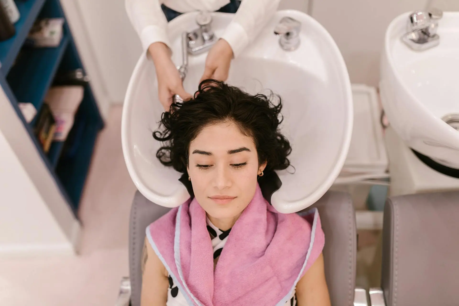 Woman applying scalp serum in hair care routine with supplements in 2025